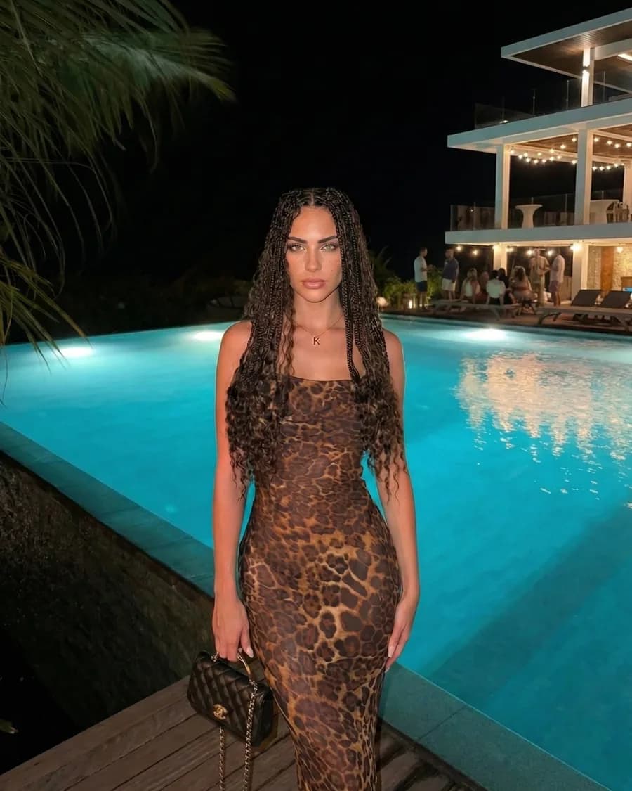 Katy in a leopard dress beside a pool at night